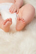 © T. Rose/peopleimages.com - Baby feet, cute and toes in bedroom, blanket and playtime in diaper for child development in skin care. Infant, kid and wellness for newborn, adorable and rug in house for home and toddler fun