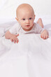 © T. Rose/peopleimages.com - Bed, blanket and face of baby in studio on a white background for child development, care and growth. Sleep, leisure and isolated newborn rest, relax and nap for childhood, wellness and comfort