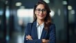 © ORG - Indian businesswoman wearing a shirt and standing outside a meeting room Portrait of happy businesswoman wearing glasses