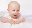 © T. Rose/peopleimages.com - Baby, excited and smile with laying on bed for curiosity, child development and relax on bed at house. Adorable, kid and cute infant in home for playful, laugh and fun with happiness in nursery