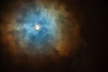 Wall Mural - The Moon in the sky on a cloudy night is surrounded by colored clouds