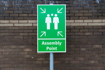 Fire assembly point sign at workplace signpost