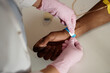 © Seventyfour - Close up of unrecognizable nurse putting patient ID bracelet on hand in clinic copy space