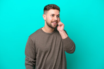 Young caucasian man isolated on blue background thinking an idea while looking up