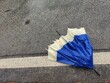 broken umbrella abandoned on the street