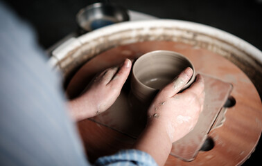 Unrecognizable Ceramics Maker working with Pottery Wheel in Cozy Workshop Makes a Future Vase or Mug, Creative People Handcraft Pottery Class