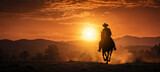 Fototapeta Konie - A lone cowboy and his trusty steed, silhouetted against the fiery orange hues of a desert sunset.