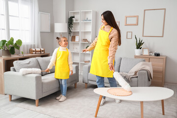 Canvas Print - Happy mother and her little daughter with pp-dusters cleaning living room together