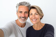 Middle aged couple over isolated white background making a selfie