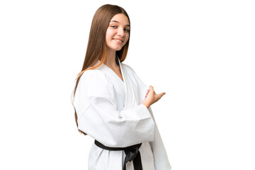 Poster - Teenager girl doing karate over isolated chroma key background pointing back