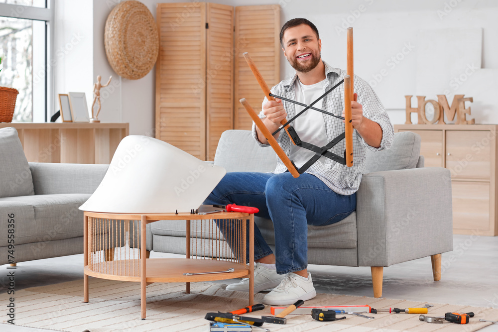 Young man assembling chair at home