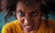 Angry grin of african american black curly young woman or girl looking at camera