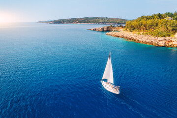 Wall Mural - aerial view of sailboat on blue sea at sunset in summer. travel in sardinia, italy. tropical seascap