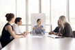 © fizkes - Businesspeople discuss deal, planning cooperation, take part in educational seminar or training led by young and ambitious female coach. Negotiation event, workshop, teamwork of corporate staff member