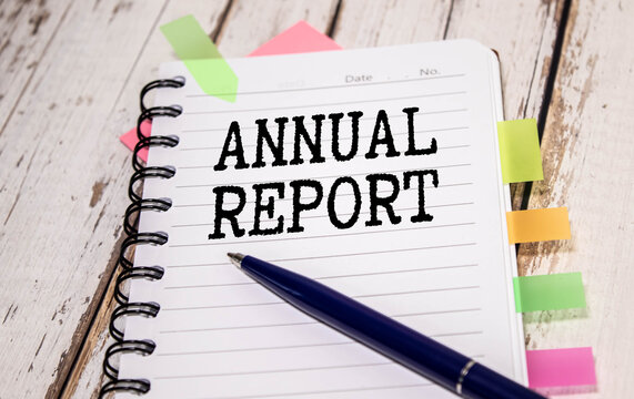 Annual report text memo written on a grey background with pencils