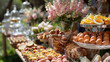 Easter brunch buffet with baked goods, pastries, eggs and fresh spring flowers in garden setting