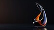 © Татьяна Макарова - An abstract glass sculpture captivates with its fluid form and fiery colors, against a dark, reflective surface
