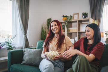 two women caucasian teenage friends or sisters watch movie tv at home