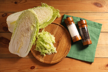 Fresh Chinese cabbage and spices on wooden table, flat lay