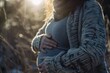 A close up of a pregnant woman cradling her belly with gentle hands against a backdrop of soft natural light embodying the beauty of motherhood