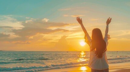 Rear view Beautiful asian woman stretching arm up into sky feeling happy at the beach with sunset.