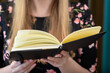 Młoda dziewczyna blondynka z otwartą książka w ręku, czyta książkę 