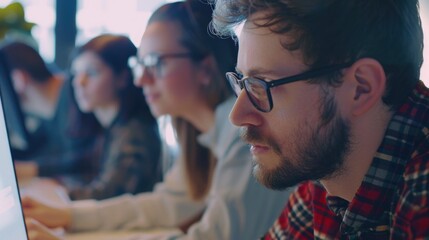 Poster - A group of people sitting in front of a laptop computer. Perfect for technology and teamwork concepts