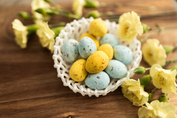 Wall Mural - Yellow flowers and pastel yellow and blue colored eggs in a white small wicker basket on a background of brown wood. Layout. Mockups. Pastel Springs background. Easter background. Easter eggs close up