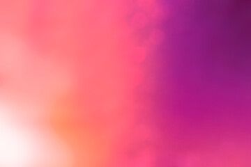 Soft and glowing orange, purple and pink color gradient background with bokeh effect. Abstract bright, vibrant, blurred and multi-colored background. Copy space.