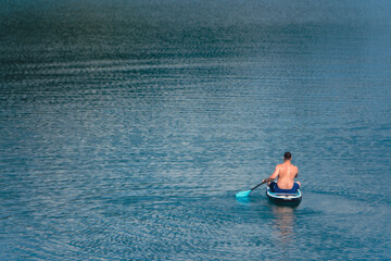 Wall Mural - man on paddleboard in the middle of the lake