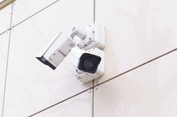 Dual Security Cameras Mounted on a White Wall