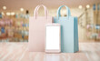 smartphone with shopping bags against blurry shop interior,business,shopping and e-commerce concept image,copy space for text