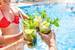 © Davide Angelini - Happy friends drinking mojito cocktails at summer pool party - Young people celebrating summer holidays outdoors - Food and beverage life style concept