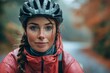 A young woman wearing a cycling helmet and jacket poses with raindrops visible, showcasing an autumn cycling theme