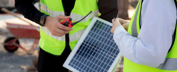 Team young engineer or architect meeting and planning installation solar panel at construction site, engineer talking and discussing with partner for installation solar cell, industry concept.