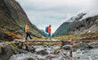 © Soloviova Liudmyla - Trekkers Couple crossing river by wooden bridge on Mera Peak trekking route near Kothe. Man and woman returning down to valley and enjoying Makalu Barun National Park valley view.