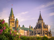 Parliament of Canada and Library of Parliament on hill, during spring with lilac flowers, Ottawa, Ontario, Canada. Photo taken in May 2022.