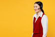 Side view fun employee operator business woman in set microphone headset for helpline assistance wear red vest shirt sit work at call center office isolated on plain yellow background studio portrait.