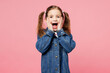 Little child surprised shocked cute kid girl 7-8 years old wears denim shirt have fun look camera hold face isolated on plain pastel light pink background. Mother's Day love family lifestyle concept.
