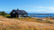 small rural cottage in a grassy clearing near the sea in scandinavia.