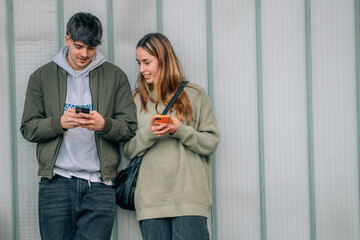 Poster - urban young couple with mobile phones on the street wall