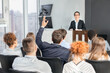 © Prostock-studio - Businessman raising hand at seminar, having question to speaker