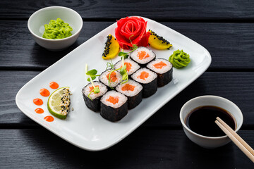 Poster - Set of sushi rolls from salmon, rice and nori with wasabi, ginger and soy sauce.