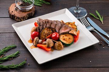 Wall Mural - Dinner beef slices with grilled eggplant, zucchini, cherry tomatoes, mushrooms and bell peppers.