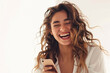 © Hunman - Beautiful Latin laughing while using a smartphone against white background.