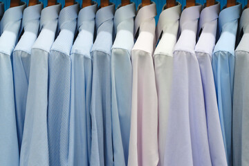 Aufkleber - Multi-colored men's shirts on hangers in a store or store