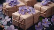 a close up of three wrapped presents with purple flowers on the side of the box and a string of twine with purple flowers on the side of the present box.