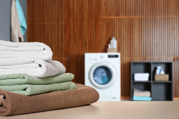 Poster - Folded clean towels on table in laundry room, space for text