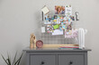 © New Africa - Chest of drawers with vision board and decor elements near grey wall indoors