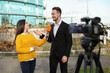 © New Africa - Young journalist interviewing businessman on city street